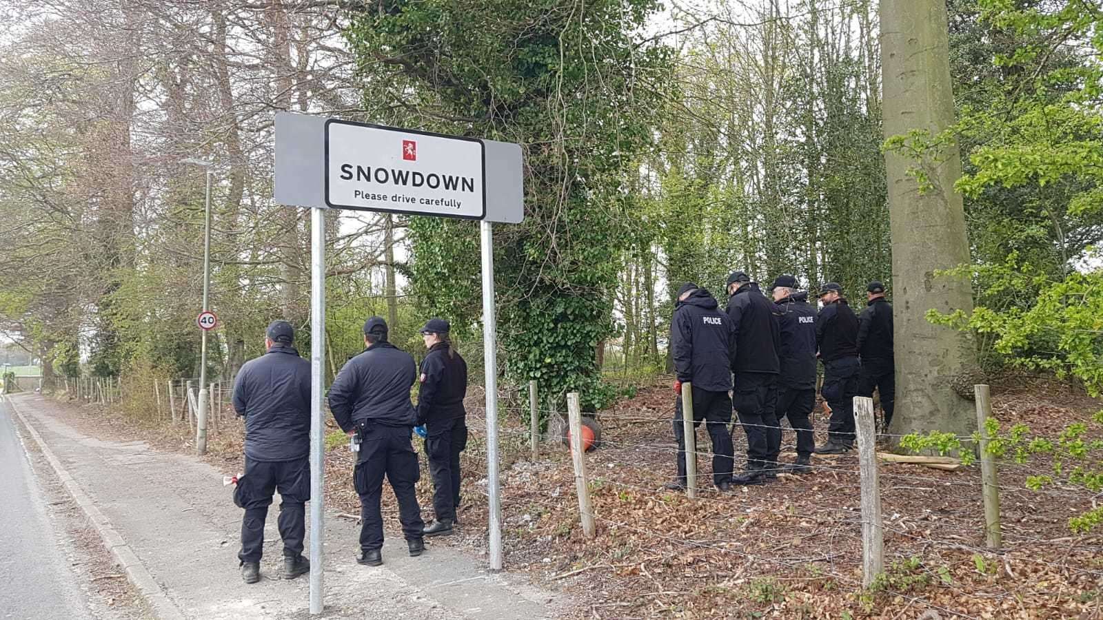 Police officers searching woodland