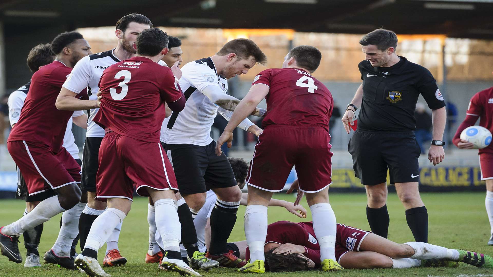 Referee Craig Hicks prepares to send off Alex Brown (on ground) folllowing a challenge on Chelmsford's Anthony Church which sparked off angry scenes between players of both teams Pic: Andy Payton
