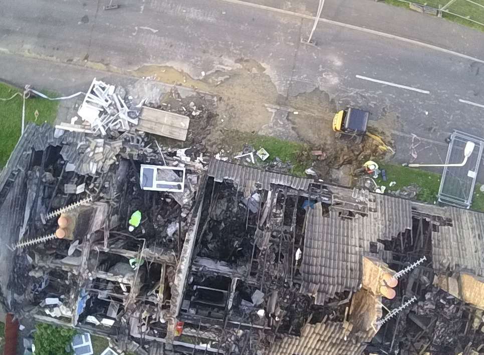 A close-up shows workmen inside the devastated homes. Picture: Lindsay Renton