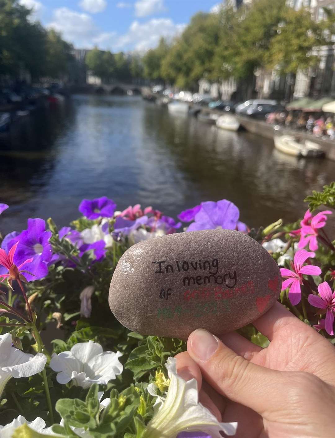 A rock reading ‘in loving memory of Griff Barnes’ held in front of a canal in Amsterdam (Matilda May Turpin/PA)