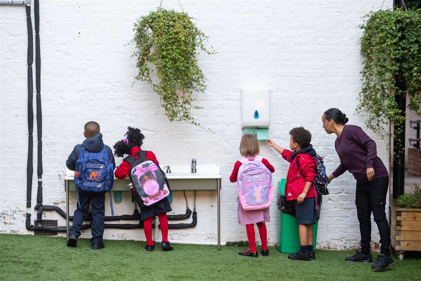 Students wash their hands before entering class (Dominic Lipinski/PA)