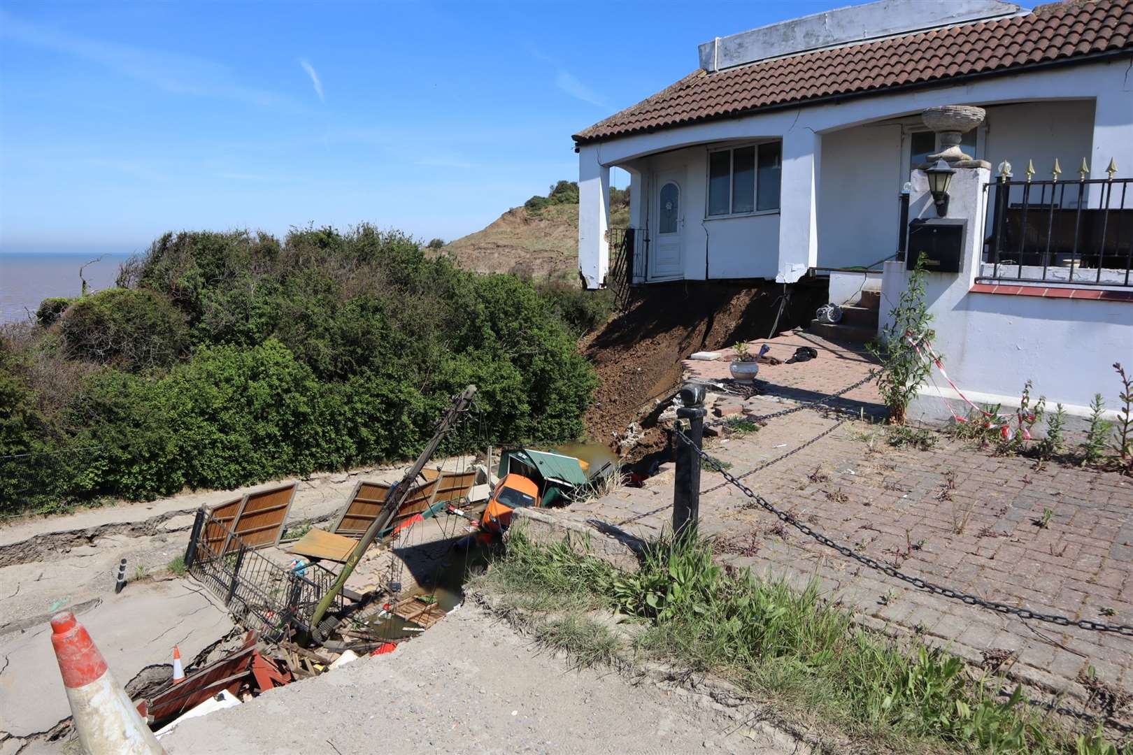 The front of Emma's home was left balanced precariously after an entire corner of Surf Crescent, Eastchurch, slid into the sea. Her car and a telegraph pole can be seen below