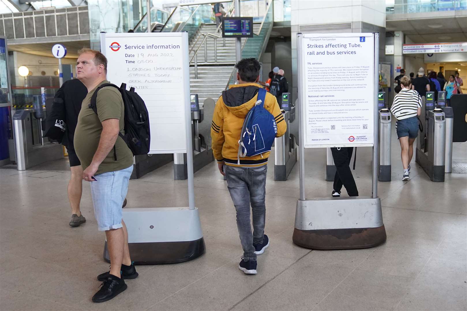 Passengers walk past information notices at Stratford station in east London (Stefan Rousseau/PA)