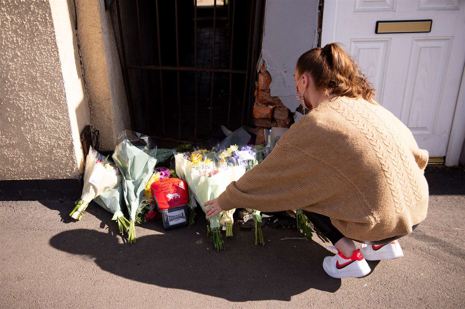 A woman leaves flowers at the scene on High Street, Brownhills (Jacob King/PA)