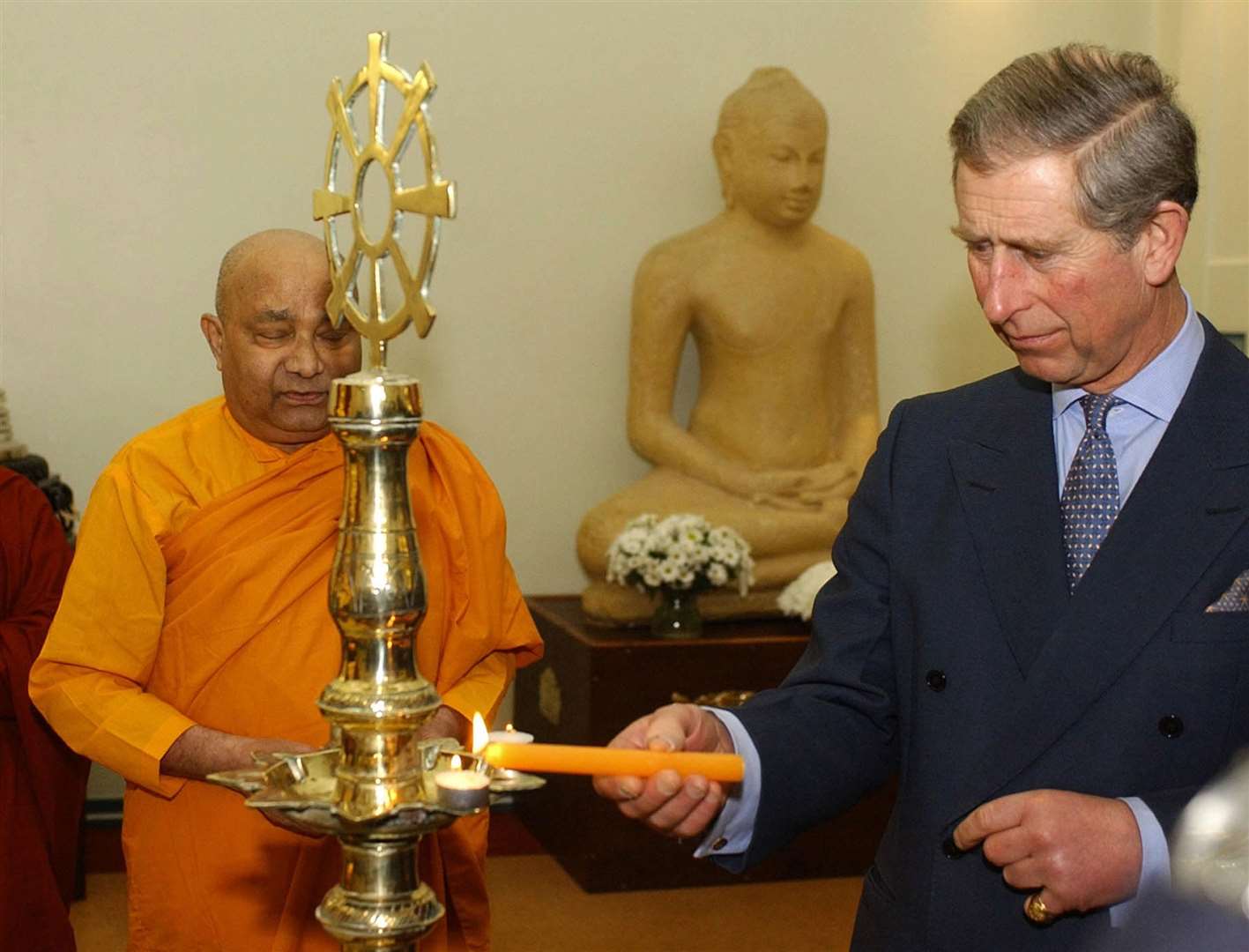 Charles lights a candle during a visit to a Buddhist temple in west London(Martyn Hayhow/WPA Rota AFP/PA)