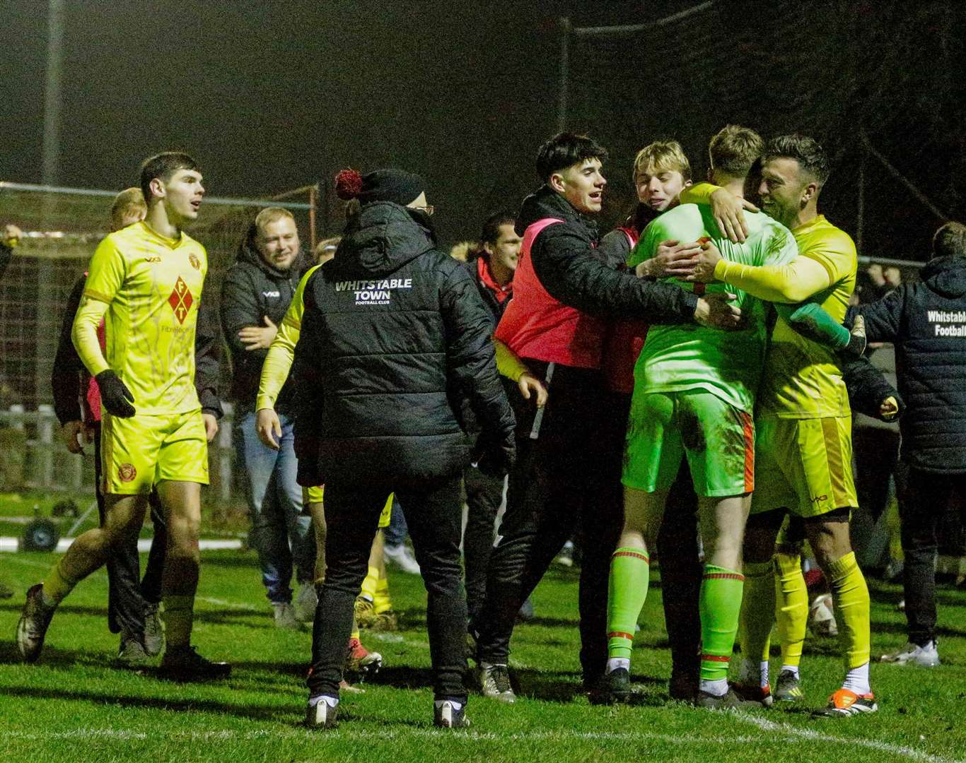 Whitstable keeper Dan Colmer (green kit) is mobbed after penalty shoot-out heroics in the FA Vase. Picture: Mark Bullimore Photography