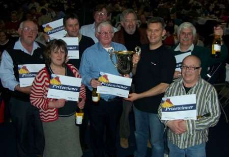 Stuart Wharf, manager of HSBC, Canterbury presents the KM Big Quiz trophy to the Bonny Cravat team.