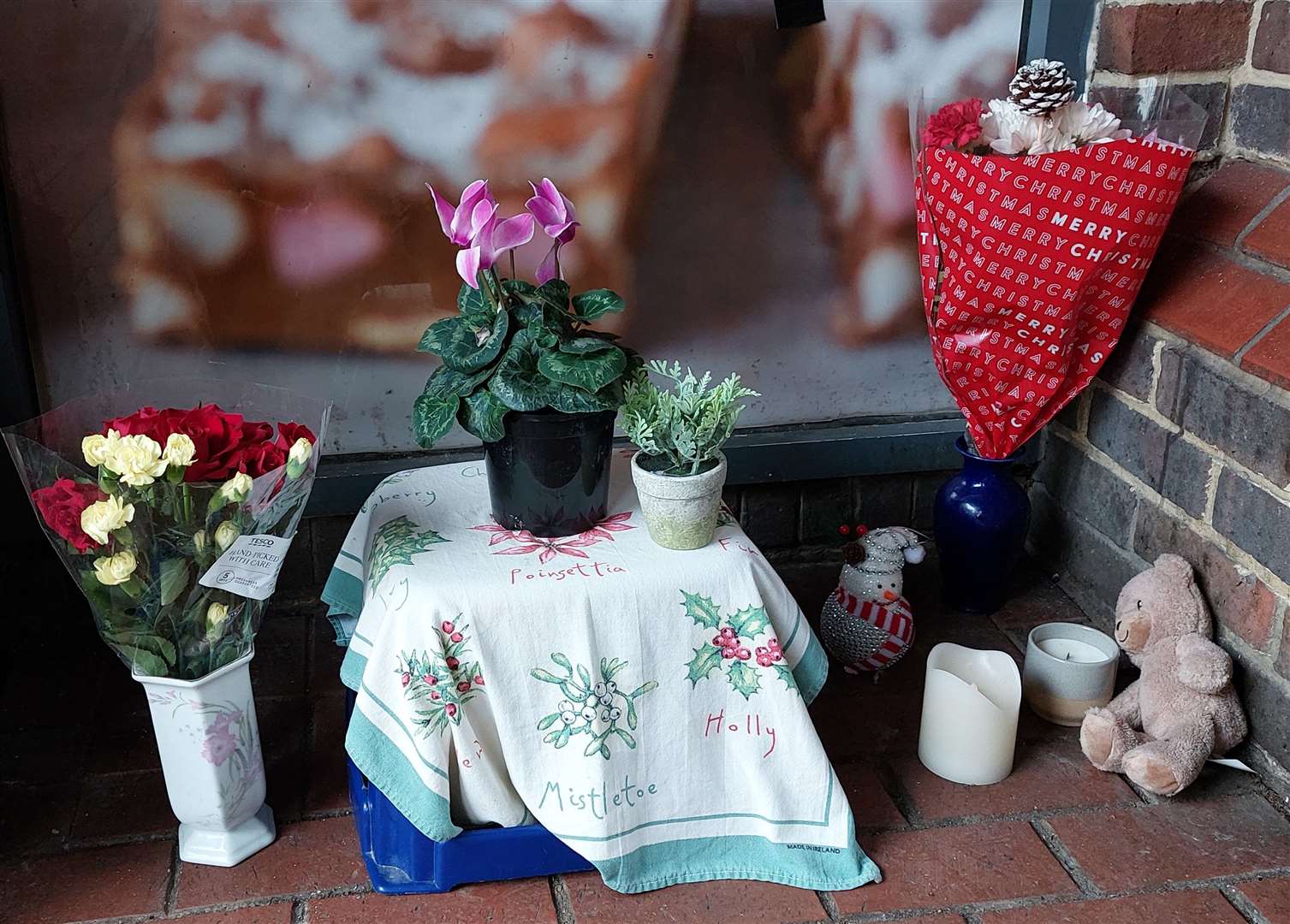 Flowers, a teddy and a candle have been placed in memory of Piotr