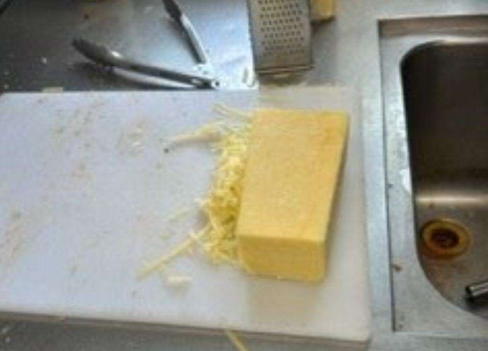 Ready-to-eat cheese being prepared on and around dirty utensils and surfaces