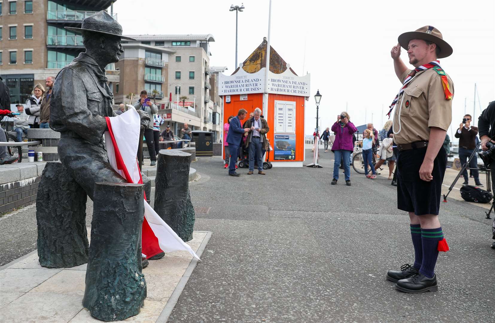 Rover Scout Matthew Trott salutes a statue of Robert Baden-Powell on Poole Quay (Andrew Matthews/PA)