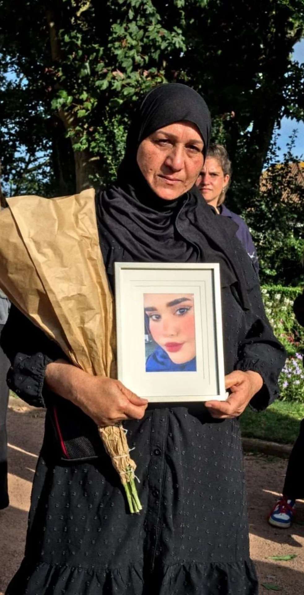 Amira Al Shammari holds a picture of her daughter (Amira Al Shammari/PA)