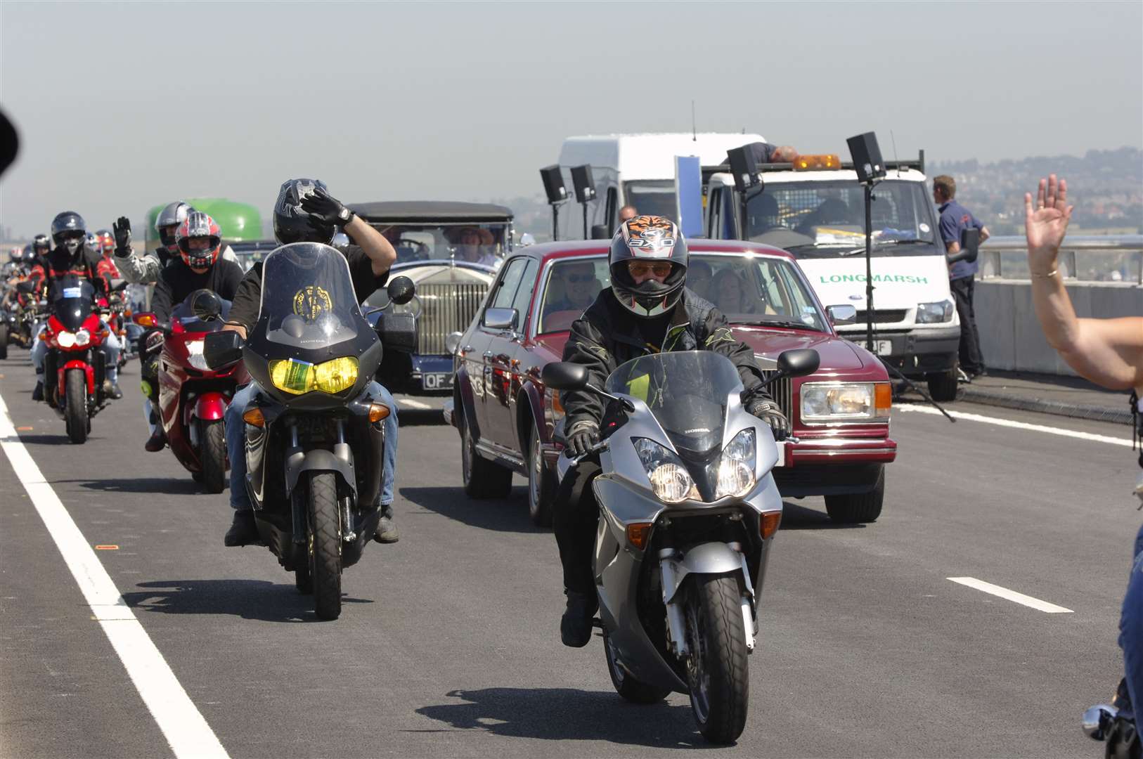 Bikes and cars parade across the new bridge on the day of its official opening