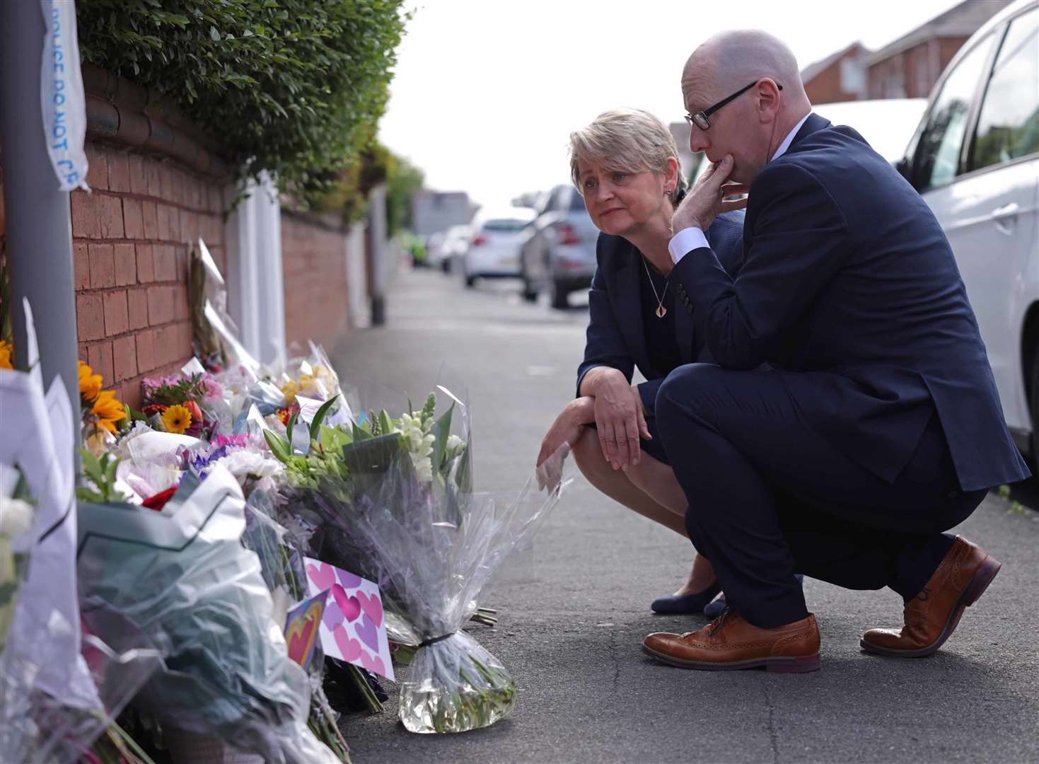 Home Secretary Yvette Cooper and Southport MP Patrick Hurley look at tributes near the scene of the attack in Hart Street, Southport (James Speakman/PA)