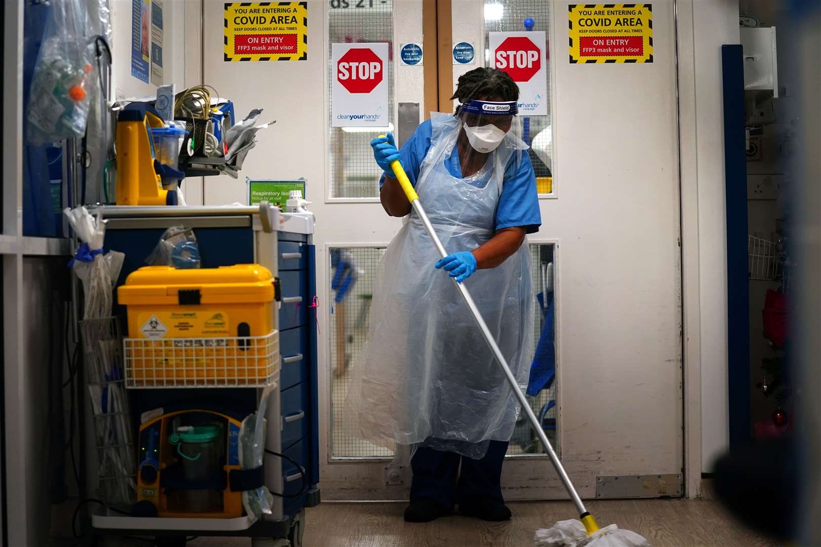 A member of staff cleans a corridor on a ward for Covid patients at King’s College Hospital (Victoria Jones/PA)