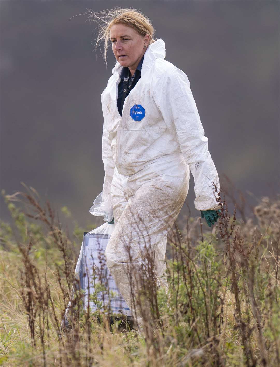 An officer carries an evidence bag (Danny Lawson/PA)