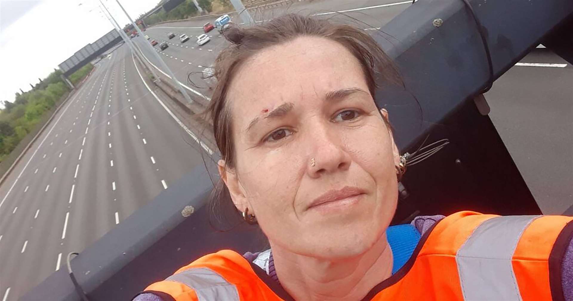 One of the activists who has climbed motorway signs on the M25 (Just Stop Oil/PA)