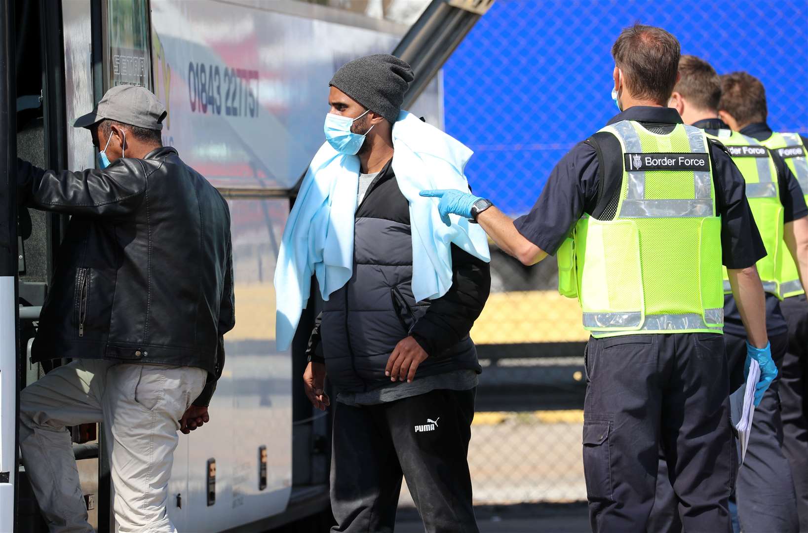 Border Force officers escort a group of men thought to be migrants on to a waiting bus after they were brought into Dover earlier this week (Gareth Fuller/PA)