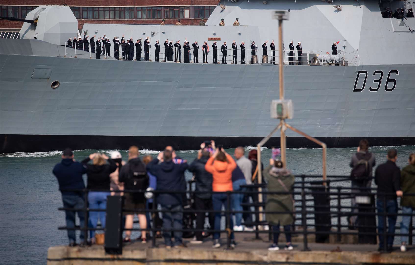 Ship’s company wave to family and friends from HMS Defender (Andrew Matthews/PA)