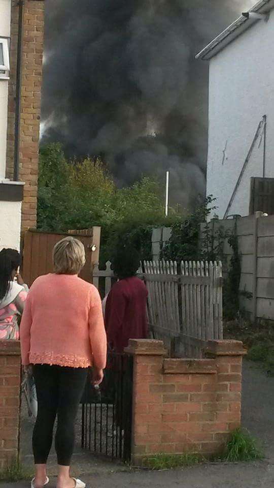 Residents watch plumes of smoke bellow from the fire in Spring Vale. Picture by Andrew McKerell