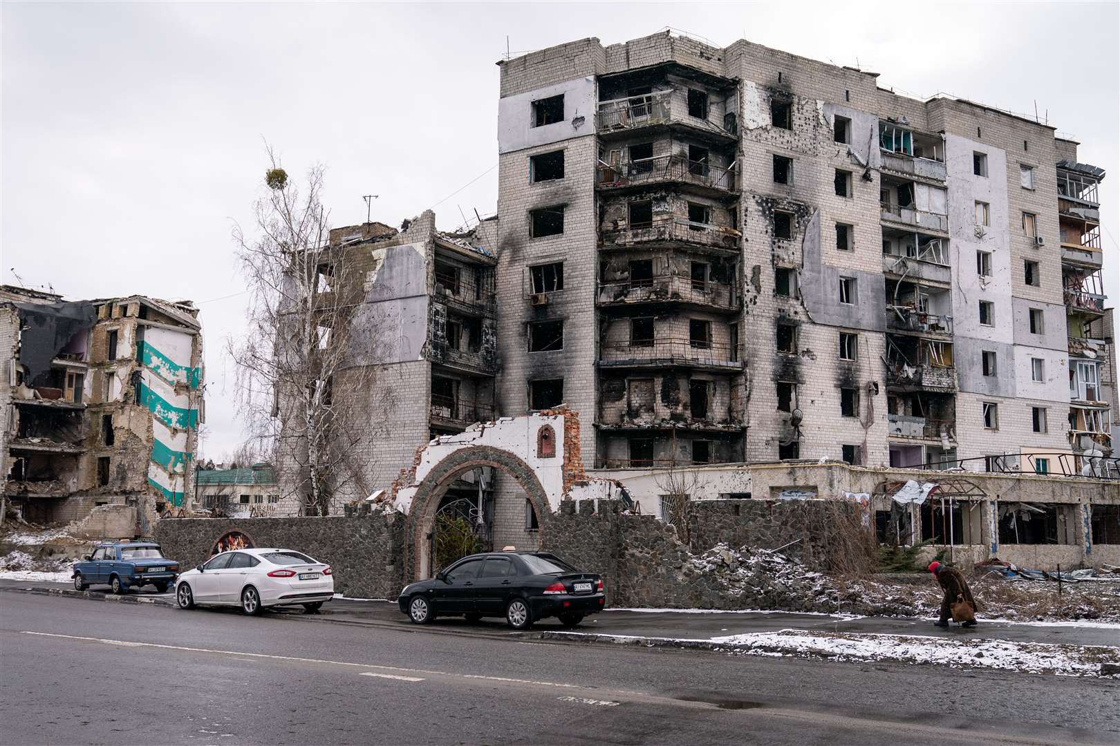 A person walks past the shell of a destroyed building in Borodyanka on the snowy outskirts of Kyiv (Aaron Chown/PA)