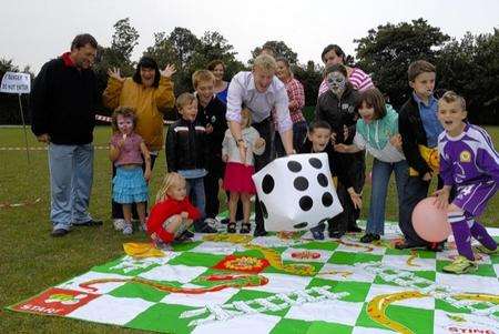 BBC South East's Bob Smith roles the dice for a game of snakes and ladders with carers
