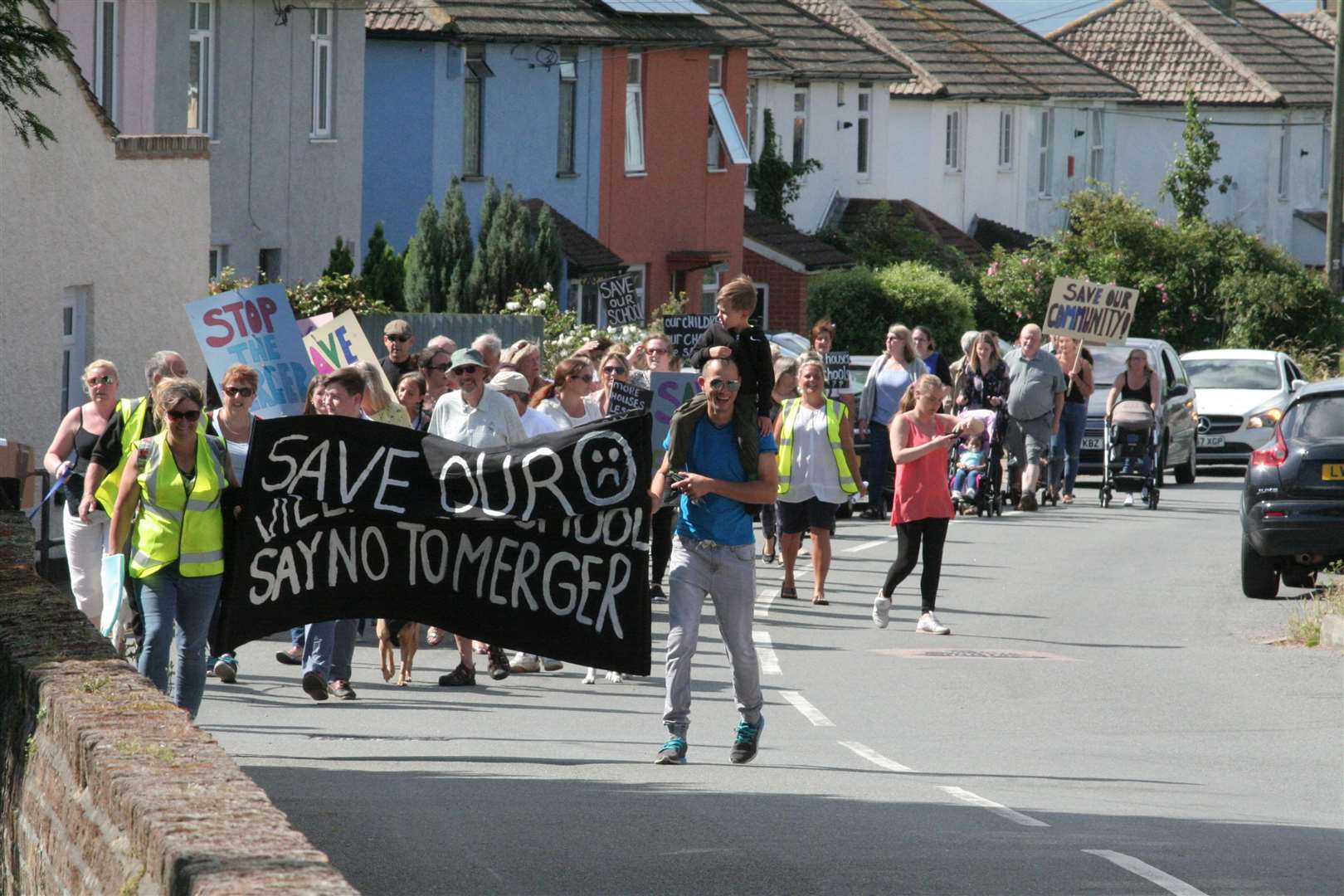 Protestors marching against merger plans in 2019