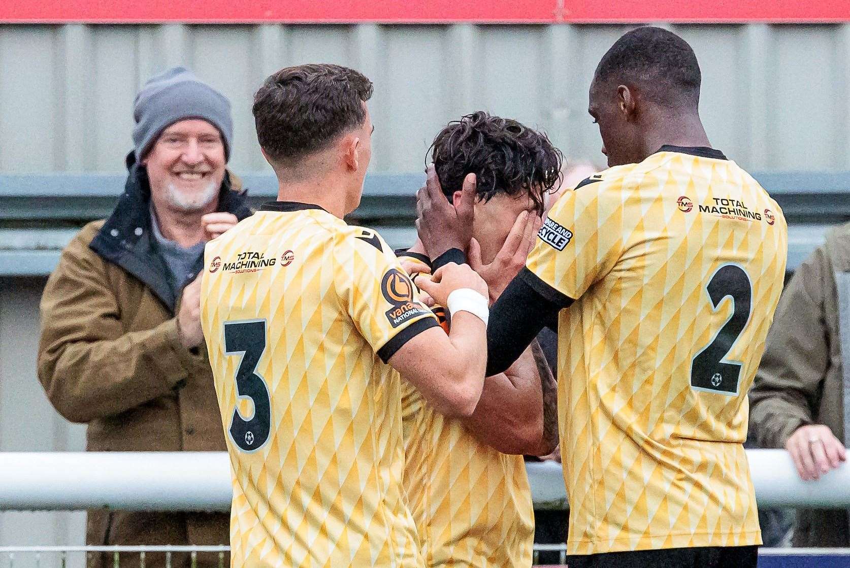 Jon Benton celebrates his goal with Maidstone team-mates Ben Brookes and Temi Eweka after scoring the only goal in the Stones’ 1-0 weekend home win - but Benton will miss out this Saturday. Picture: Helen Cooper