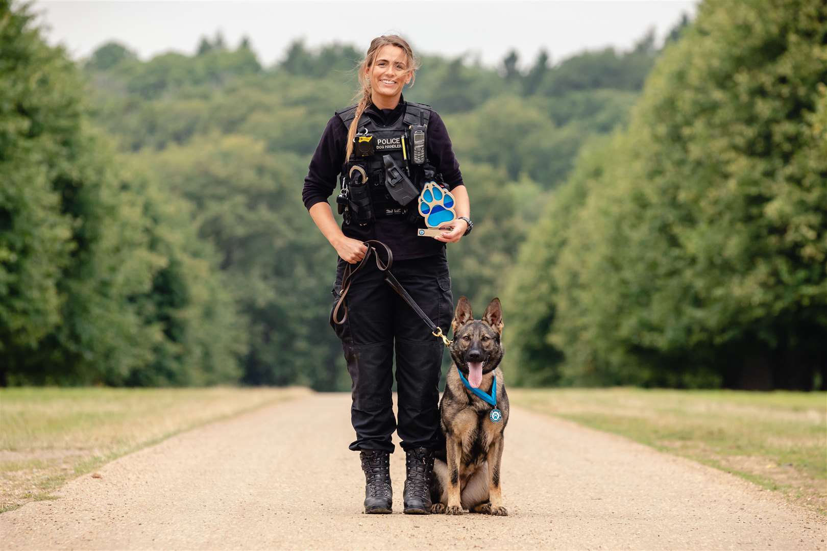 PC Megan West and German Shepherd PD Calli with their award for saving a man's life