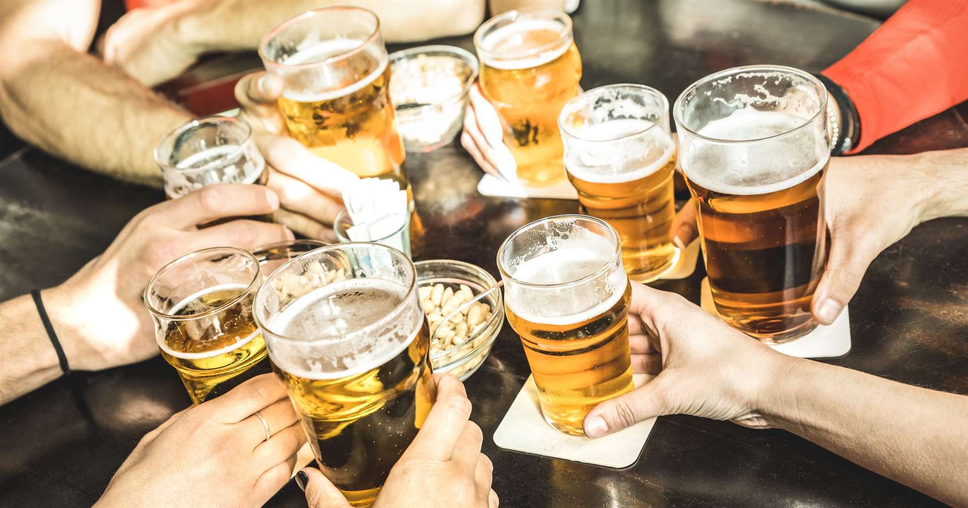 Friends hands drinking beer at brewery pub restaurant - Friendship concept with young people enjoying time together and having genuine fun at cool vintage brew bar - Focus on middle right small glass (21183573)