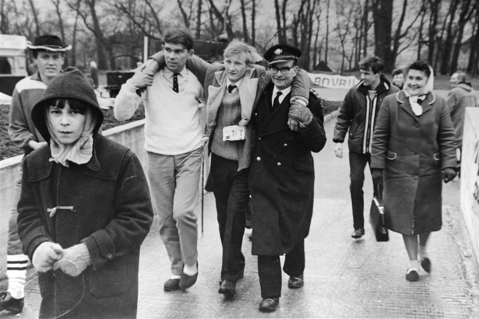 Brian (wearing a white jumper) helps cousin Derek Sylvester finish the KM 50 mile walk, assisted by a St John Ambulance man, with cousin Keith Sylvester (far left), brother Colin (in front), and mum Rene Ashby