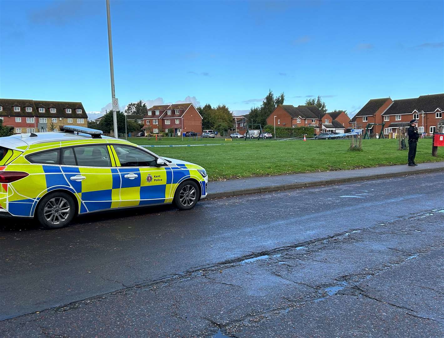 A police car at a grassy area near Lower Road, Faversham, which has been cordoned off