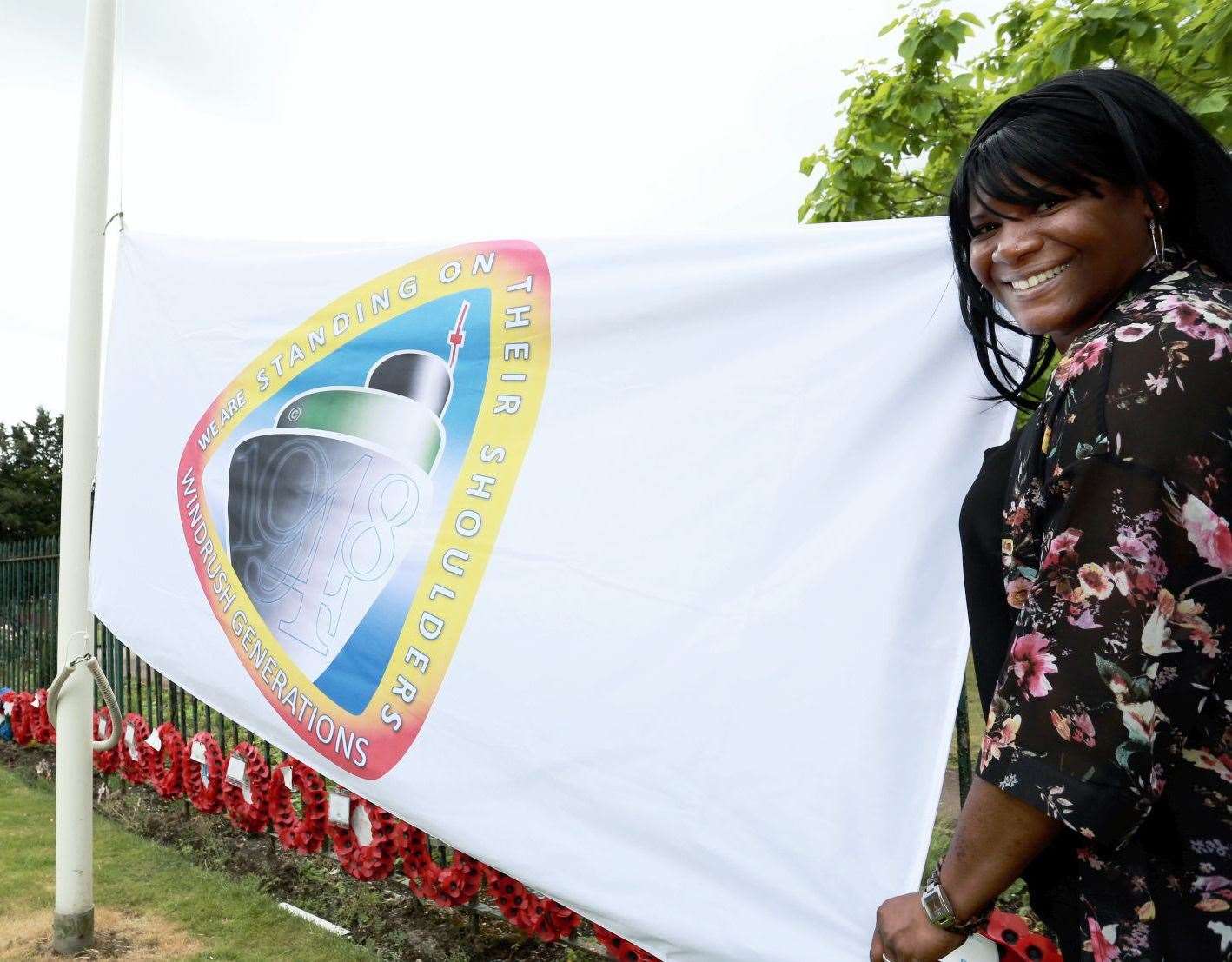 Michelle Bramble next to the flag designed to mark the anniversary