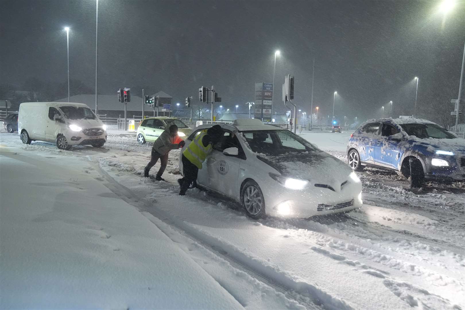 People help to push cars stuck in snow in Leeds (Danny Lawson/PA)