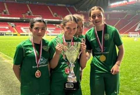 Some of Lydd Grasshoppers under-13 girls' team celebrate by the pitch at The Valley