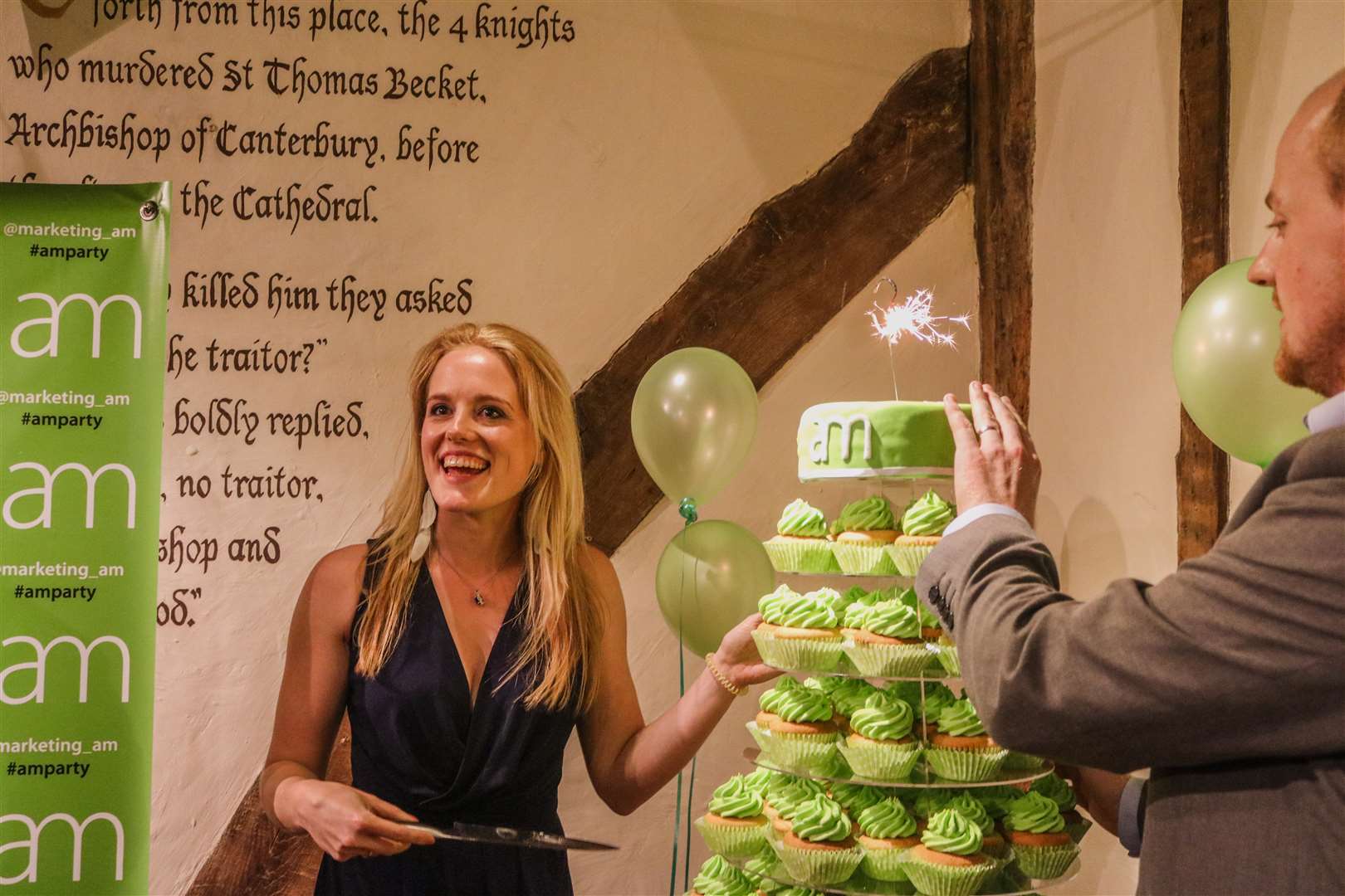 AM Marketing founder Amy McManus cuts the cake on its third birthday, watched by husband and business partner Brad