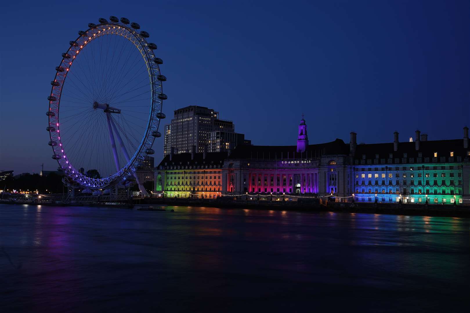 The London Eye and County Hall are lit up in a rainbow hue on the first day of Pride month in June (Aaron Chown/PA)