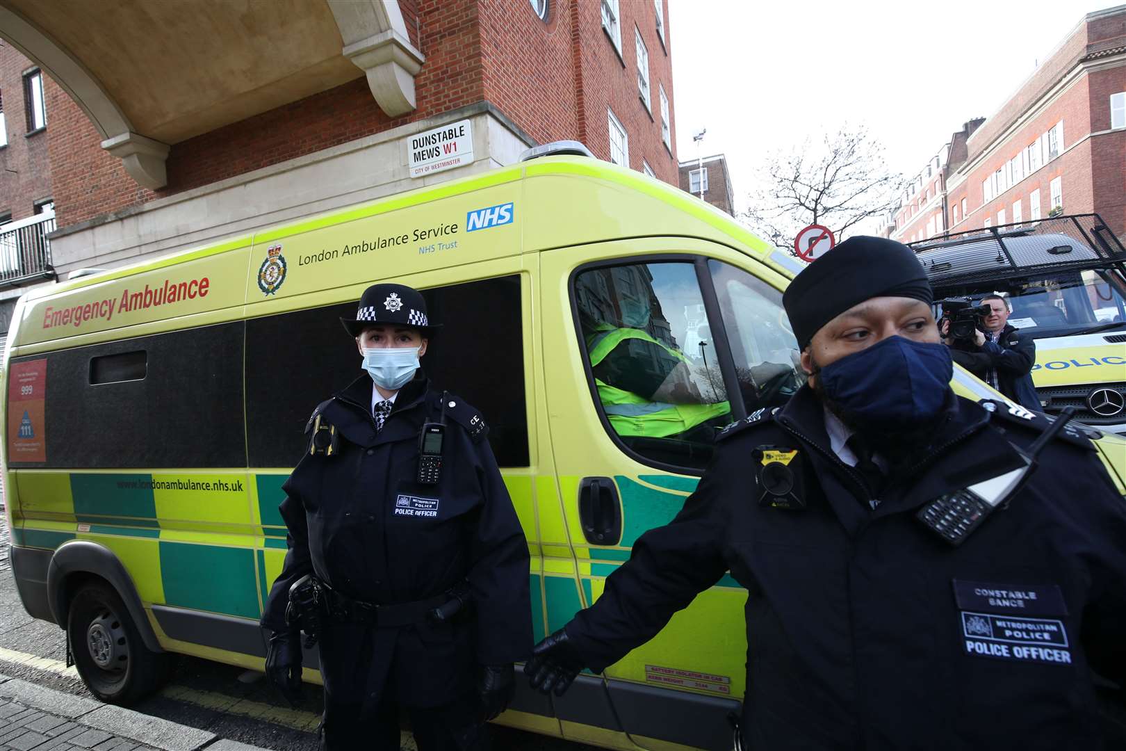 Police officers and security guards clear a pathway for the ambulance (Dominic Lipinski/PA)