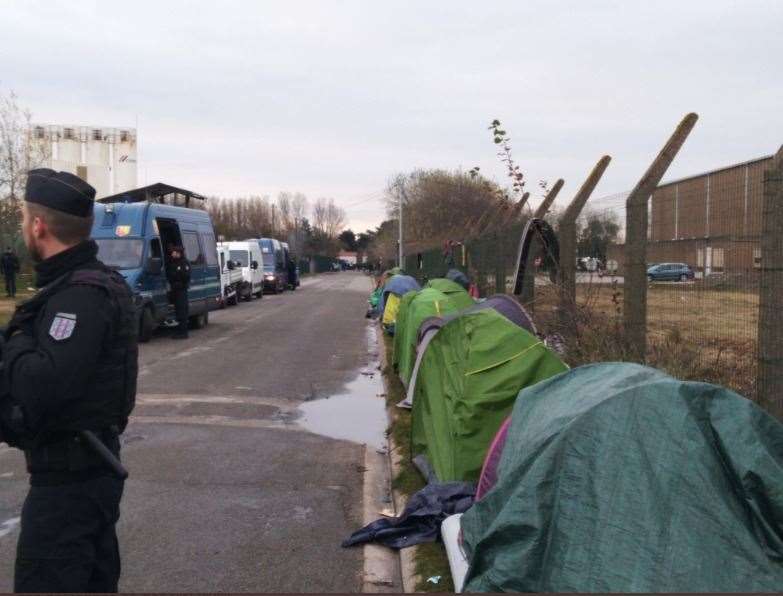 French police next to tents lining the road in Calais. Picture: Poppy Cleary