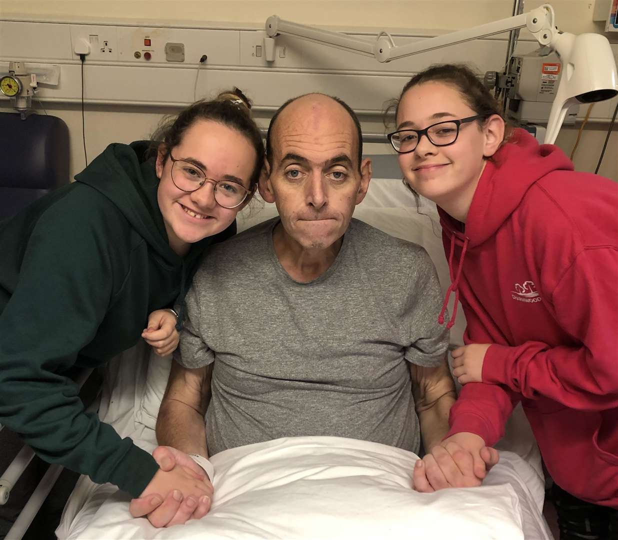 Freya Peachey, left, with her sister Matilda and dad Mike in hospital shortly before he died