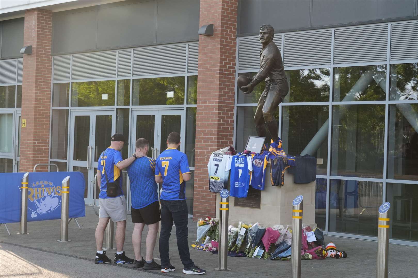 Fans look at flowers and shirts left in front of a photograph of former Leeds Rhinos player Rob Burrow outside Headingley Stadium in Leeds (Danny Lawson/PA)