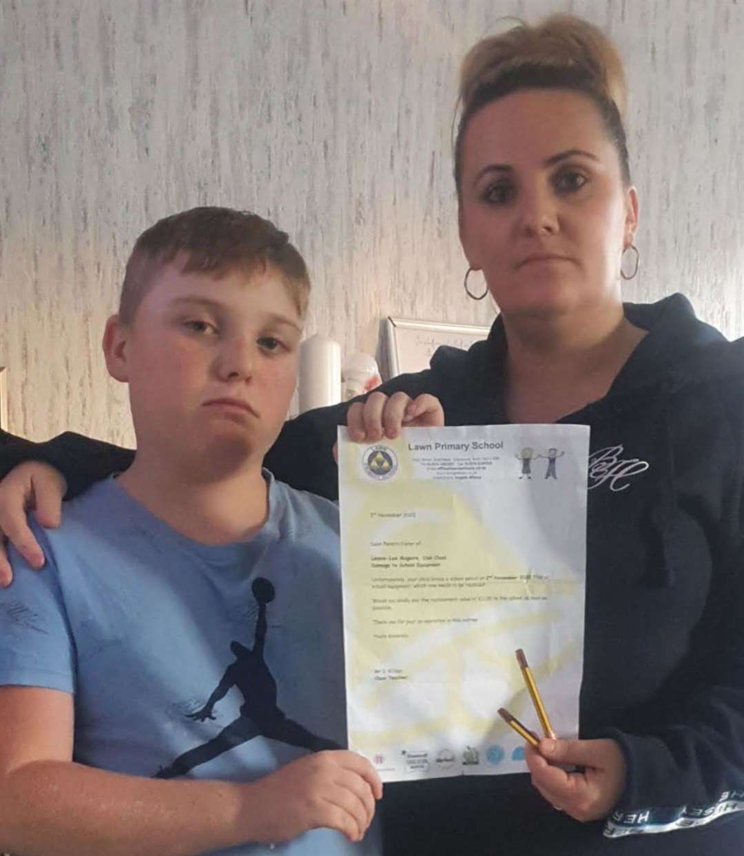 Louise Owen and her son Lennie-Lee Maguire with the letter asking for 20p to replace a broken pencil