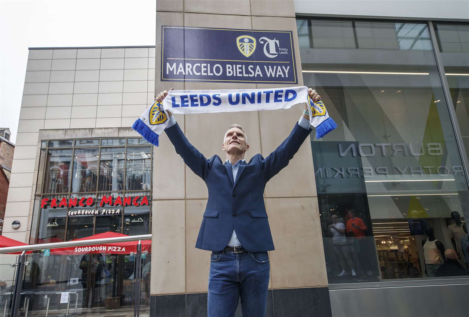 David Maddison celebrates in front of a freshly installed street sign (Danny Lawson/PA)