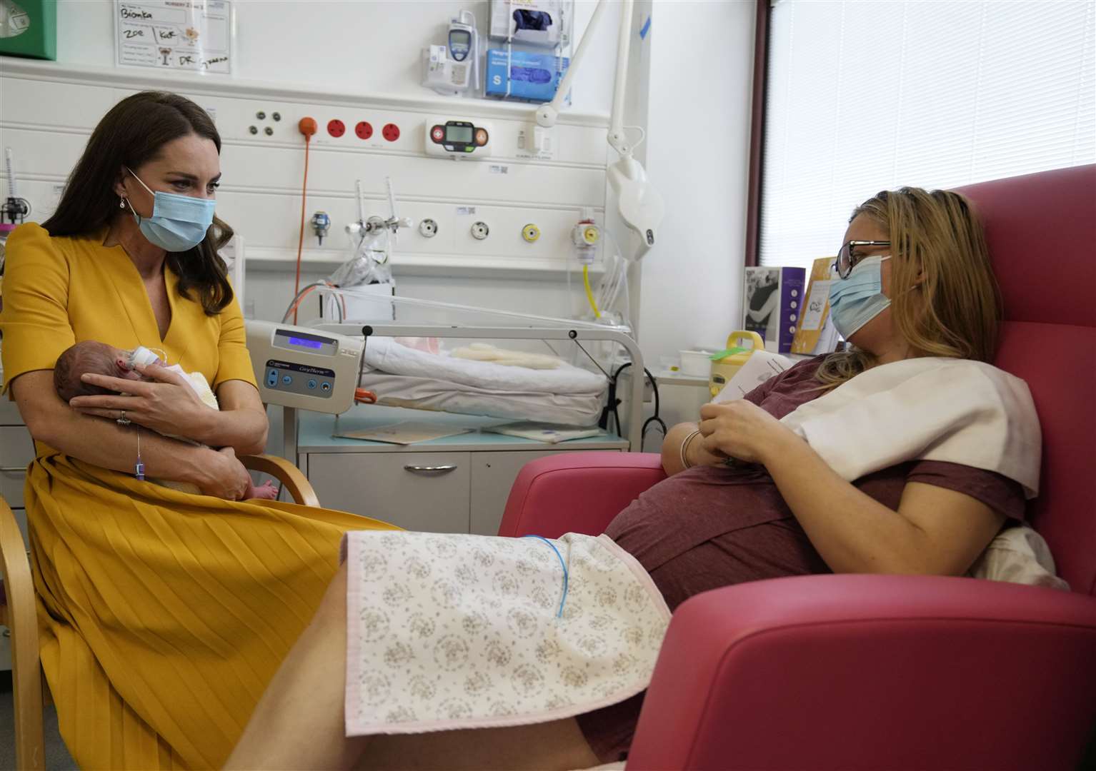 The Princess of Wales speaks to Sylvia Novak as she cradles Ms Novak’s daughter Bianca during a visit to the Royal Surrey County Hospital’s maternity unit in Guildford (Alistair Grant/PA)