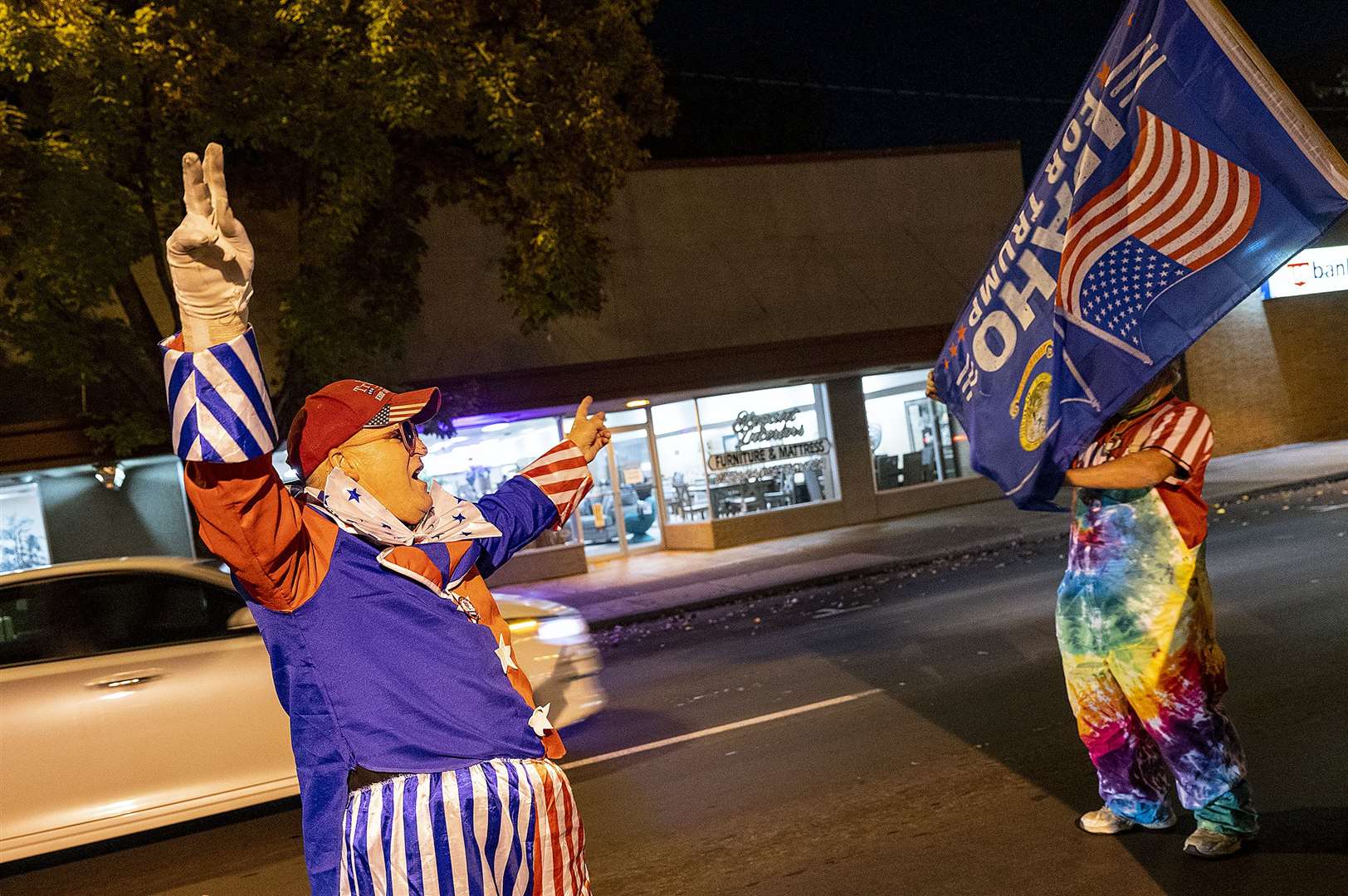 Kurt Eberhardt, left, and his twin brother Kent wave flags in support of President Donald Trump in Lewiston, Idaho (Pete Caster/Lewiston Tribune/AP)