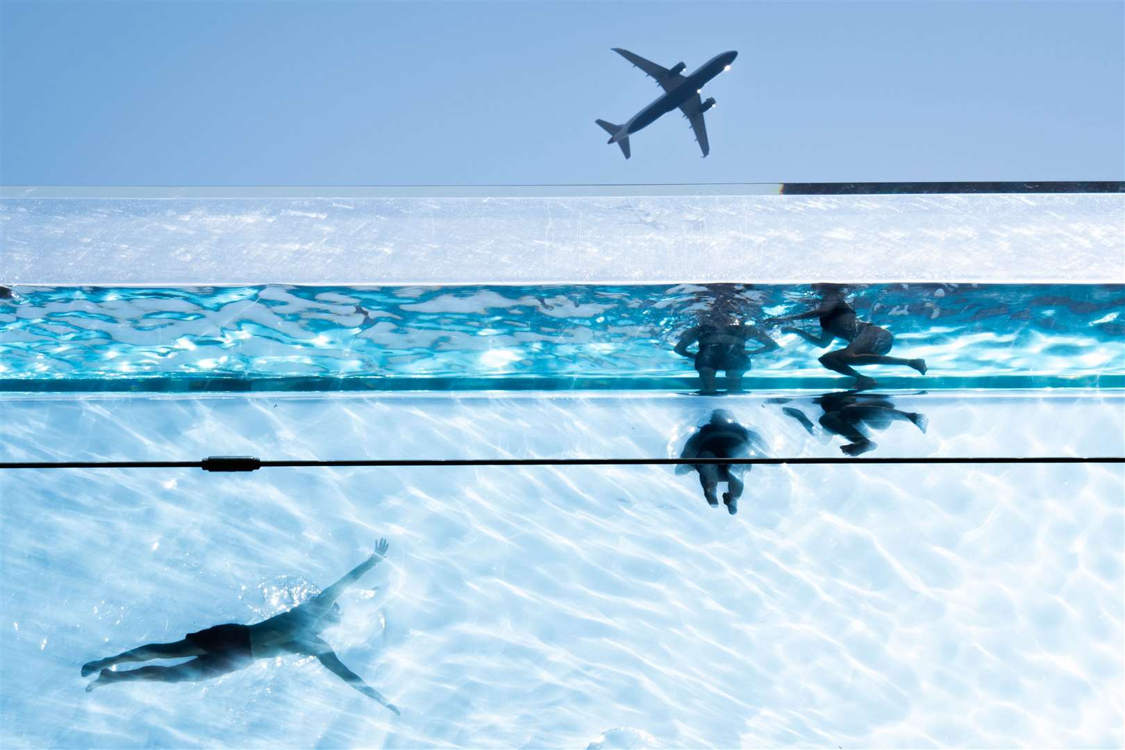 Swimmers in the Sky Pool, a transparent swimming pool 35 metres above ground between two apartment buildings, in south-west London (James Manning/PA)