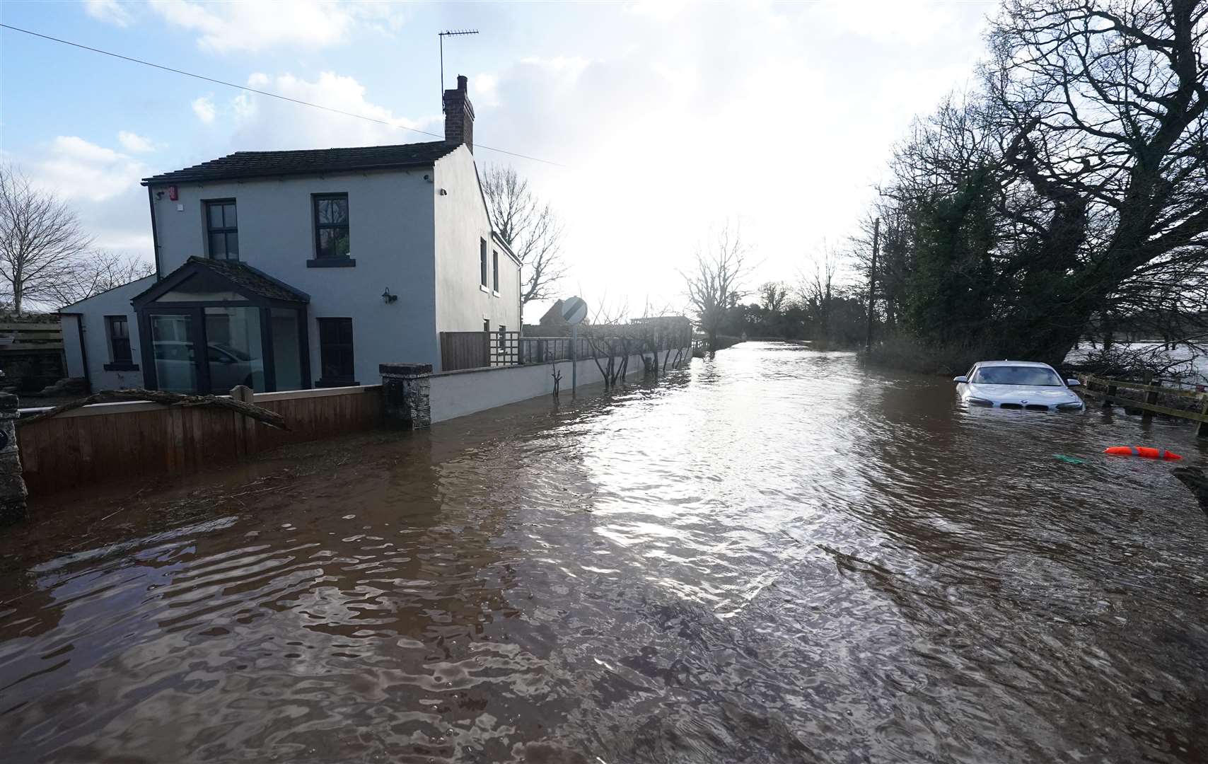 A car is stranded in flood water in Warwick Bridge in Cumbria (Owen Humphreys/PA)