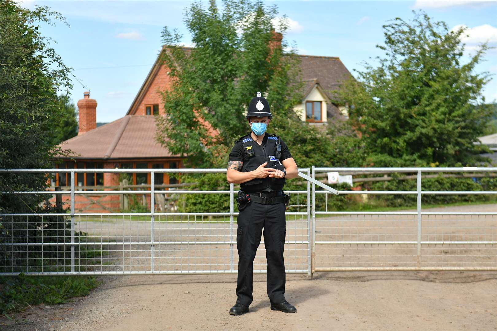 A police officer wearing a face mask at Rook Row Farm (Jacob King/PA)