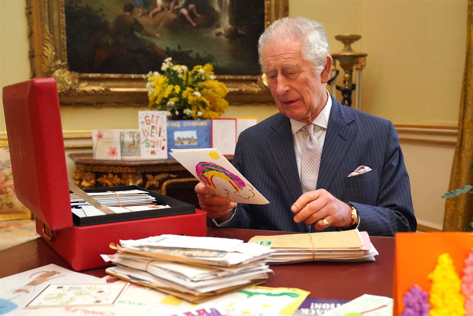 The King reads cards and messages, sent by well-wishers, at Buckingham Palace (Jonathan Brady/PA)