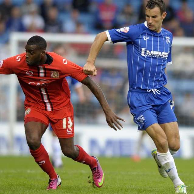 Gills' Steven Gregory takes on MK Dons' Izale McLeod last week. Picture: Barry Goodwin
