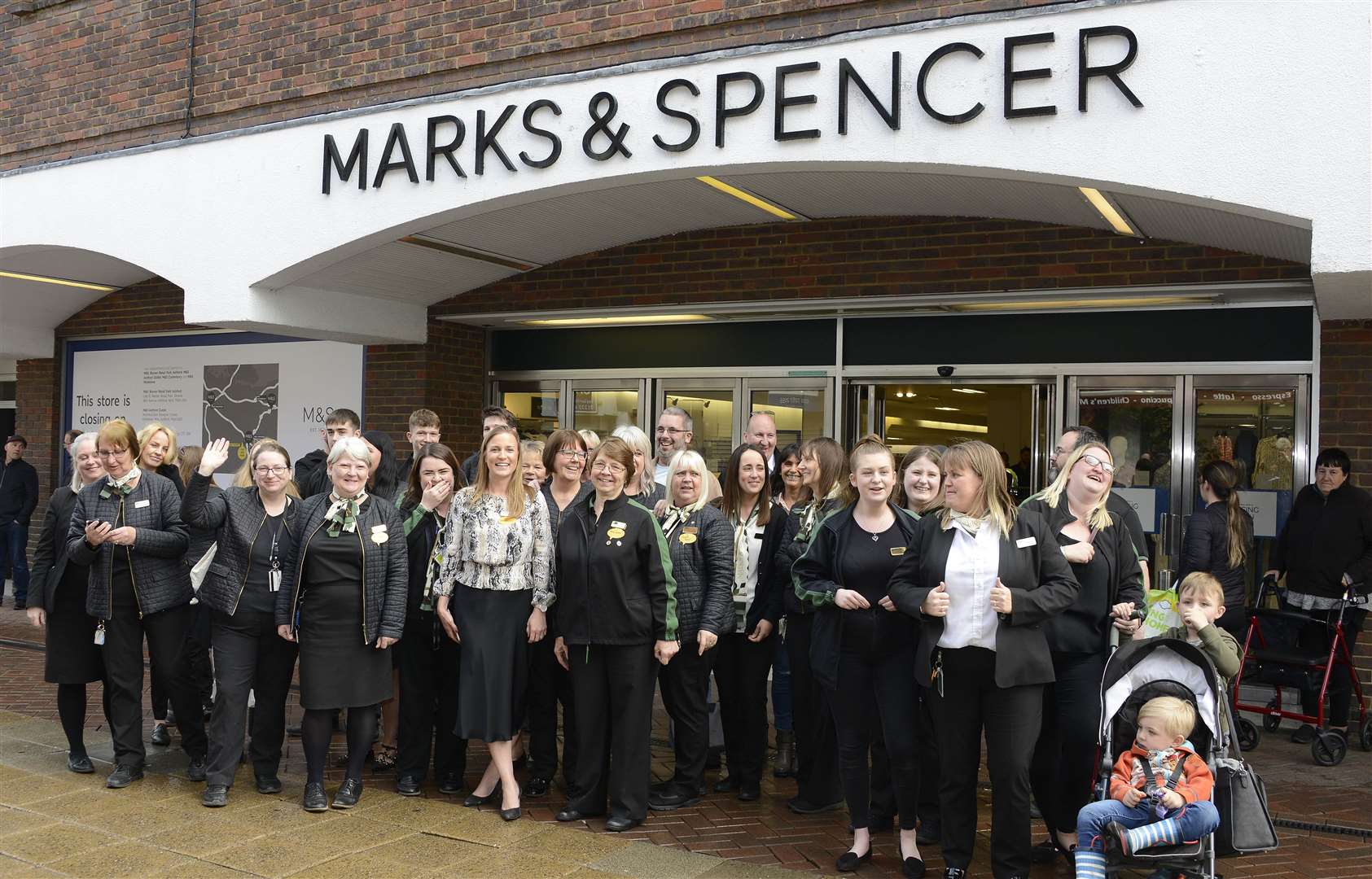 Marks and Spencer staff wave to thank customers for their support as the store closed its doors for the last time